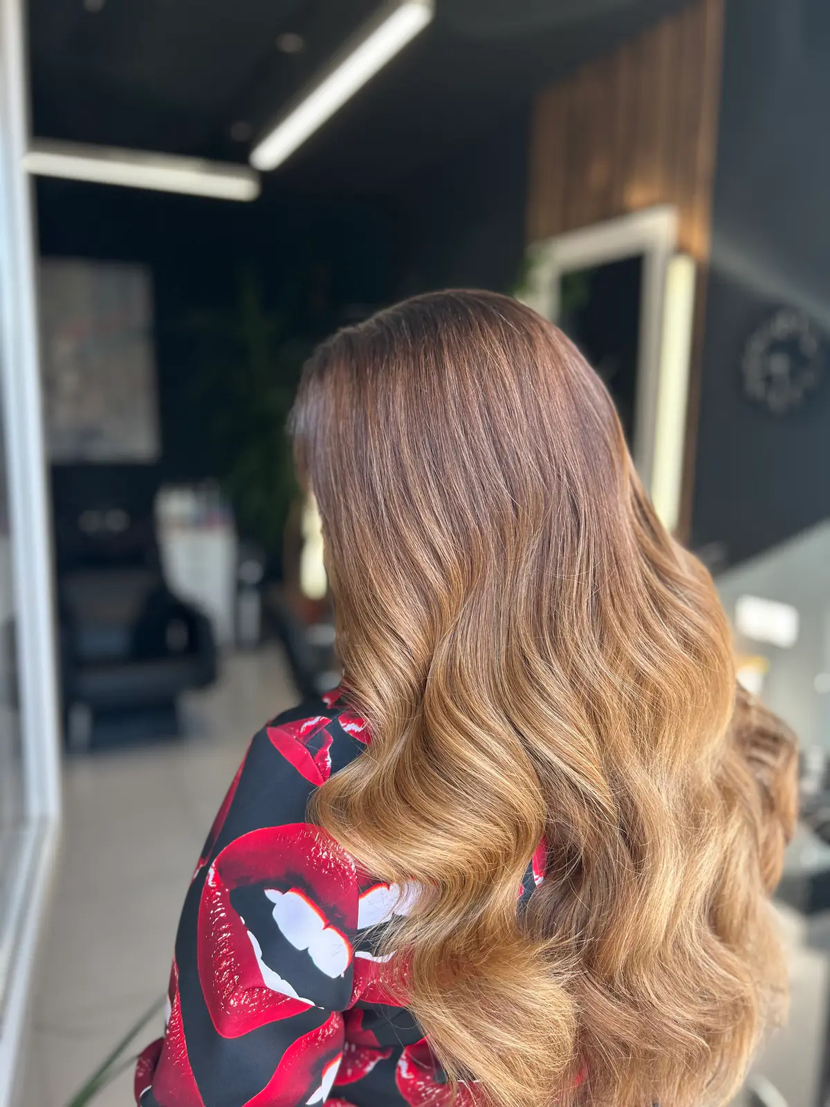 Balayage de la castaniu la blond miere pe păr lung, cu valuri ample