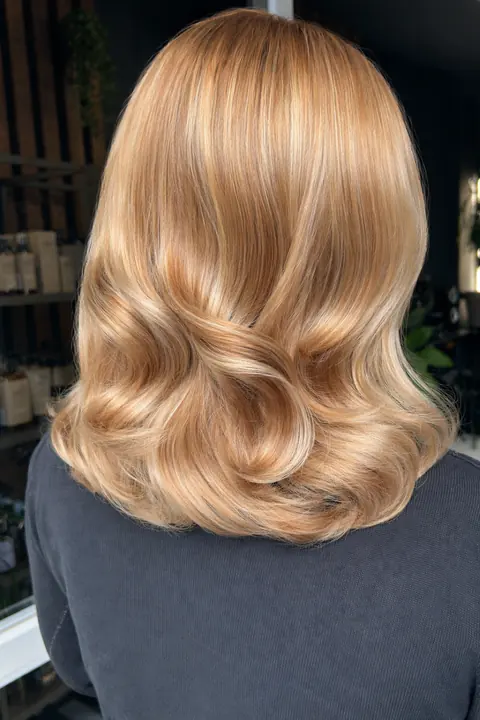 Bob blond miere cu bucle ample și luciu intens, coafat în salon