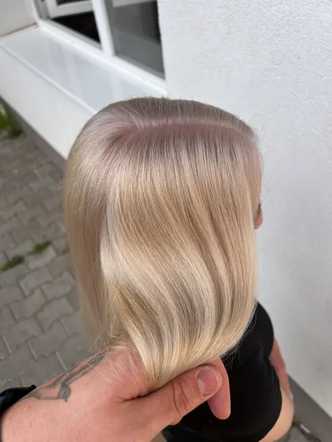 Blond glacial perlat, drept și lucios, cu rădăcină ușor umbrită, ținut în mână