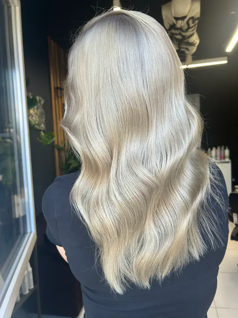 Păr blond platinat, glacial, coafat în valuri moi, realizat la BLOOM Hair Salon Târgu-Mureș