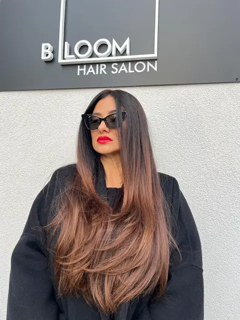 Clientă cu ochelari de soare sub logoul BLOOM Hair Salon Târgu-Mureș, cu păr lung în straturi și ombré mocha