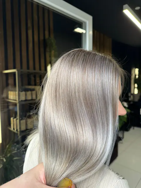 Păr drept, blond argintiu, cu luciu de oglindă, ținut în mână pentru a arăta nuanța